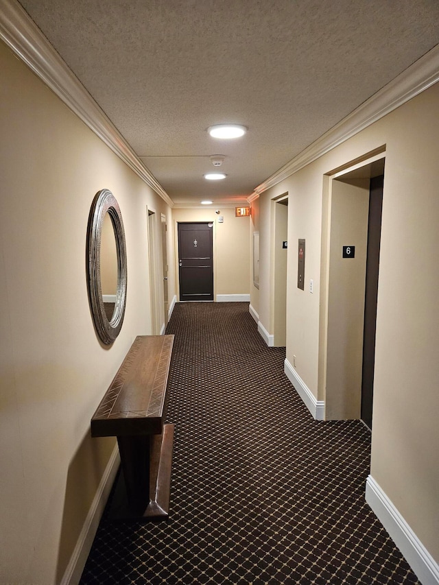 hallway featuring elevator, dark colored carpet, a textured ceiling, and crown molding