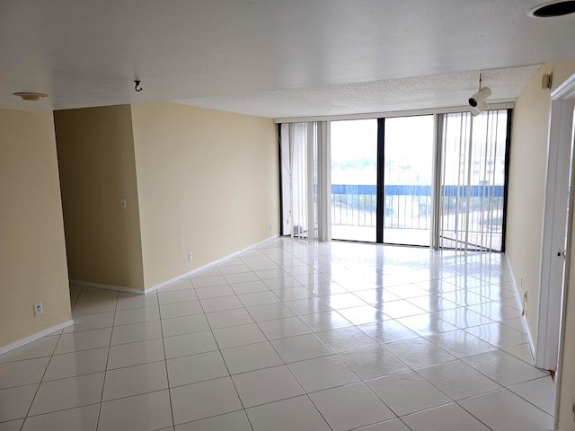 unfurnished room with light tile floors and expansive windows