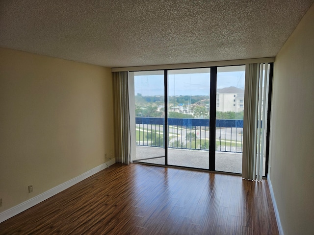 empty room featuring floor to ceiling windows, a textured ceiling, and dark hardwood / wood-style flooring