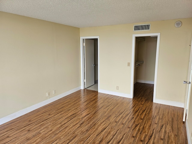 unfurnished room featuring dark hardwood / wood-style flooring and a textured ceiling