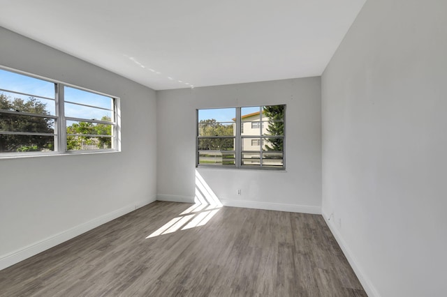 unfurnished room with dark hardwood / wood-style floors and plenty of natural light