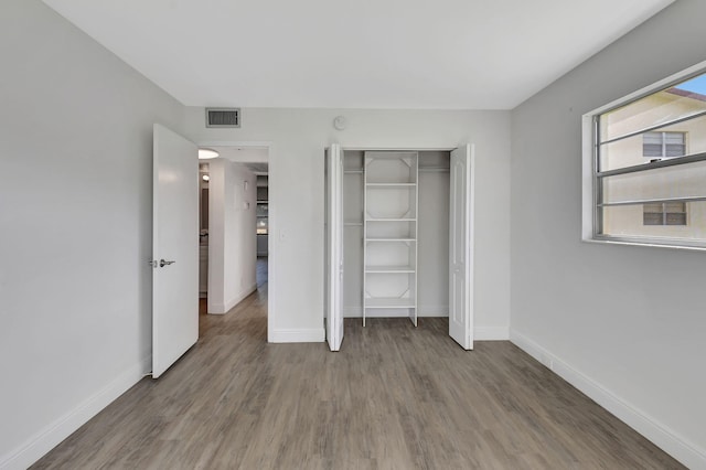 unfurnished bedroom featuring hardwood / wood-style floors and a closet