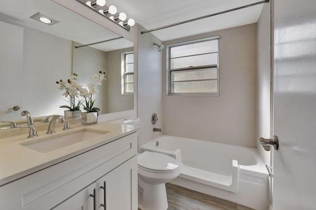 full bathroom with toilet, tiled shower / bath combo, vanity, and wood-type flooring