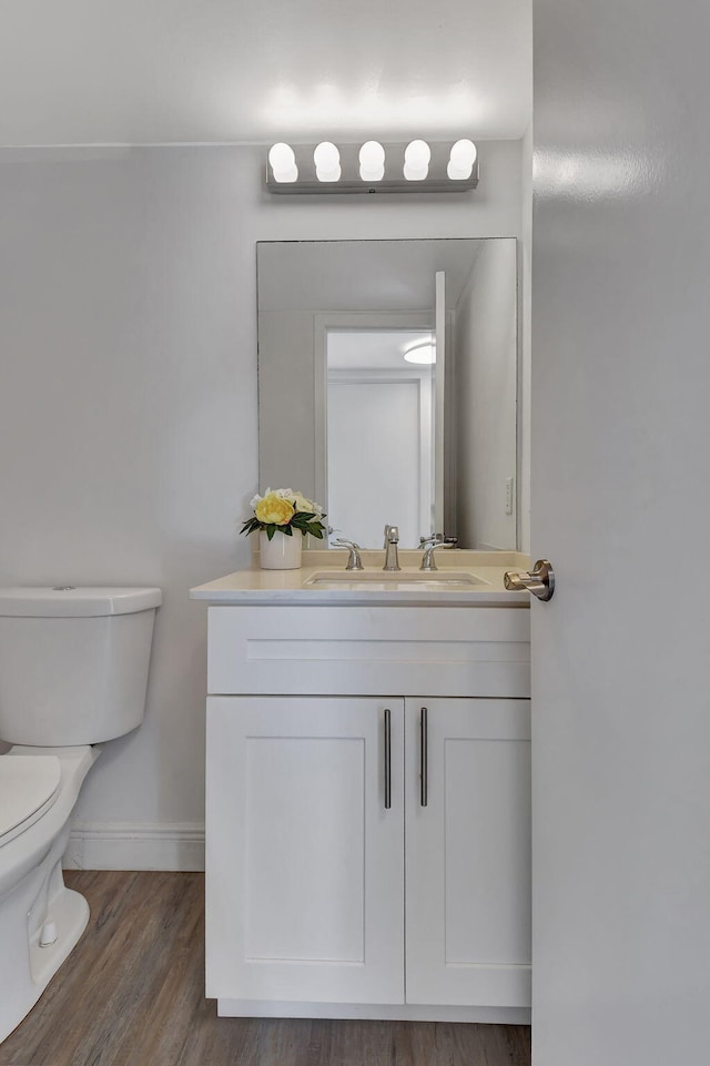 bathroom with vanity, hardwood / wood-style flooring, and toilet