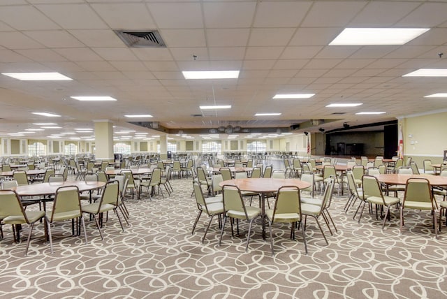 carpeted dining space featuring a paneled ceiling