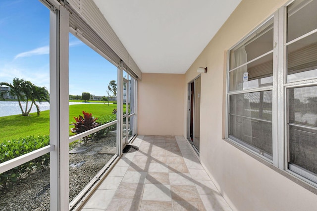 unfurnished sunroom with a water view