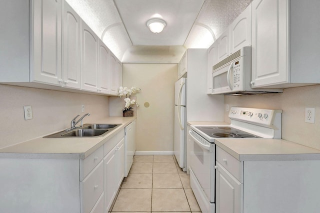 kitchen with white cabinets, sink, light tile patterned floors, and white appliances