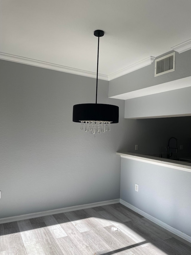 spare room with ornamental molding, light wood-type flooring, and sink