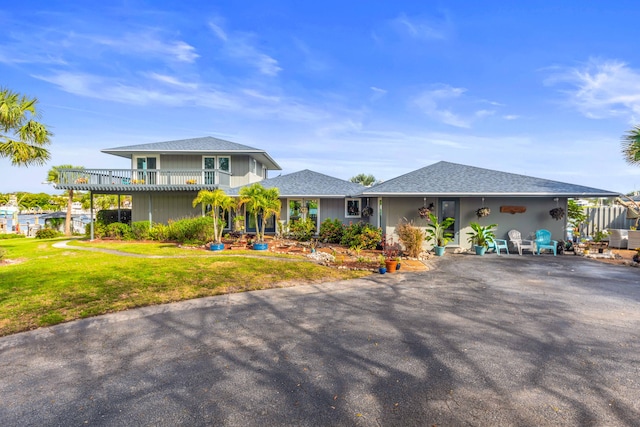 view of front of house with a balcony and a front yard