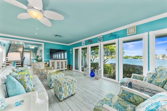 sunroom with a water view and ceiling fan