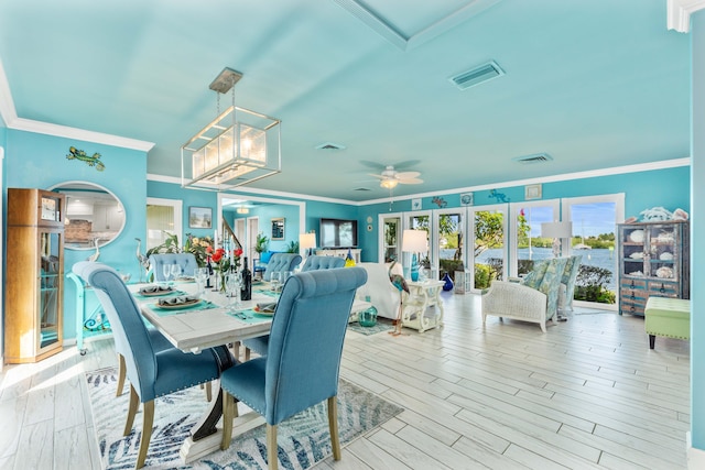 dining area with ornamental molding, light hardwood / wood-style floors, french doors, and ceiling fan with notable chandelier