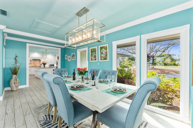 dining room with ornamental molding, a notable chandelier, light wood-type flooring, and a wealth of natural light