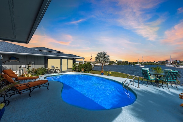 pool at dusk featuring a patio area