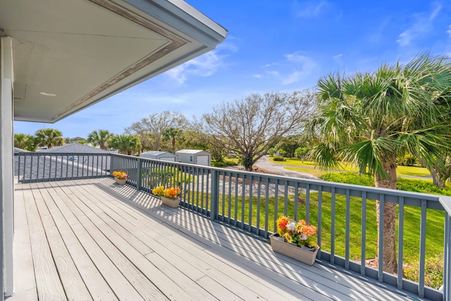 deck featuring an outdoor structure and a yard