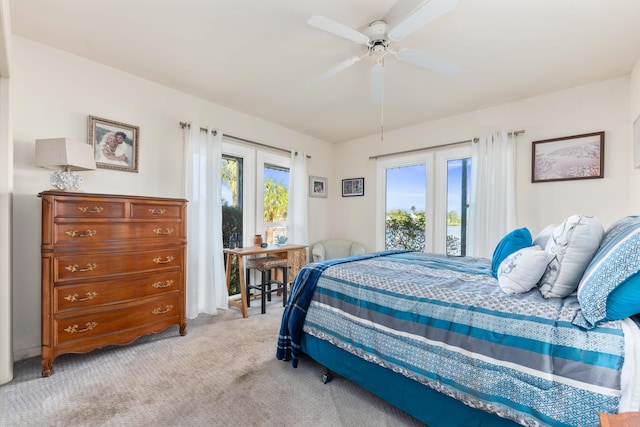 bedroom featuring access to exterior, light colored carpet, and ceiling fan