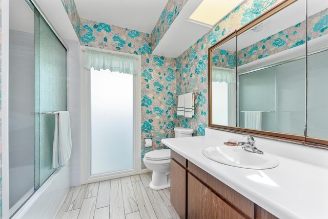 full bathroom featuring toilet, oversized vanity, and bath / shower combo with glass door