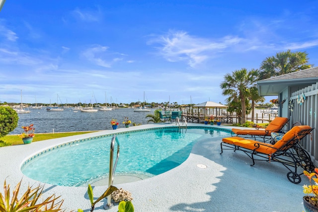 view of swimming pool with a water view and a patio area