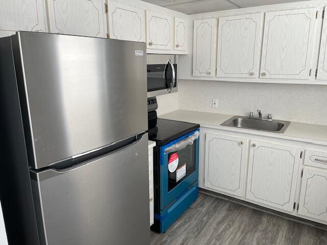 kitchen featuring white cabinetry, dark hardwood / wood-style floors, sink, and stainless steel appliances