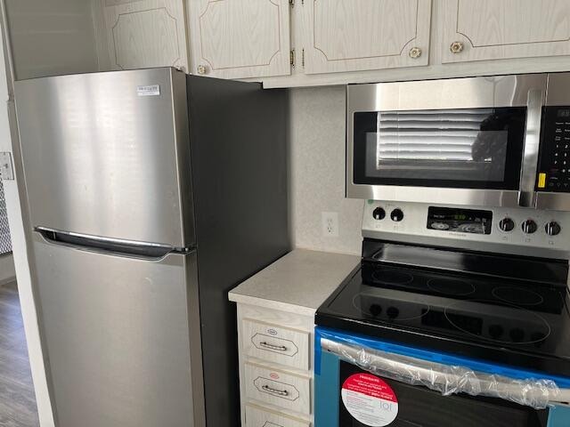 kitchen with hardwood / wood-style floors and appliances with stainless steel finishes