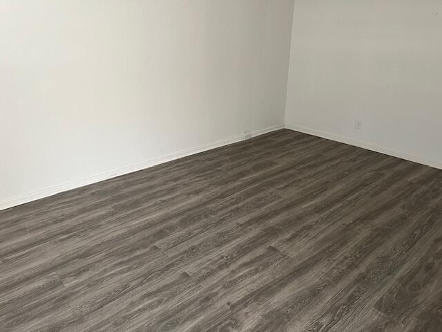 spare room featuring dark wood-type flooring