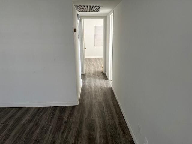 corridor with dark hardwood / wood-style flooring