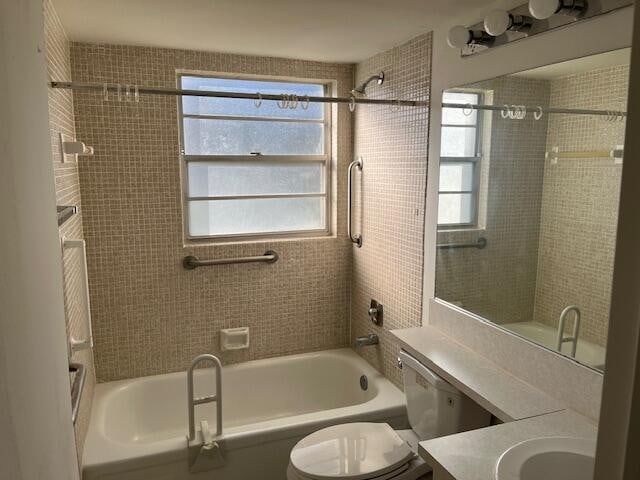 full bathroom featuring toilet, vanity, and tiled shower / bath