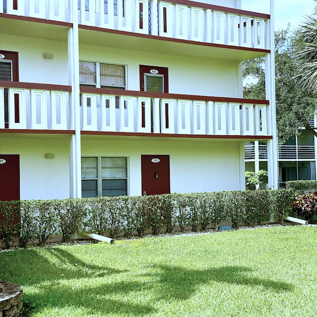 exterior space with a balcony and a front yard