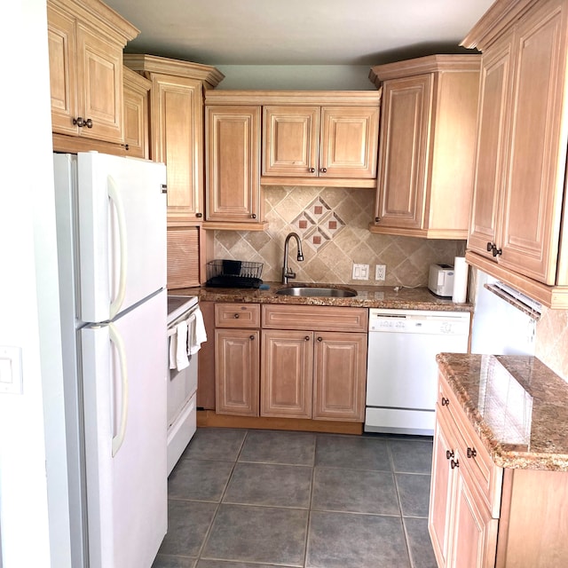 kitchen featuring white appliances, sink, dark stone counters, dark tile flooring, and tasteful backsplash