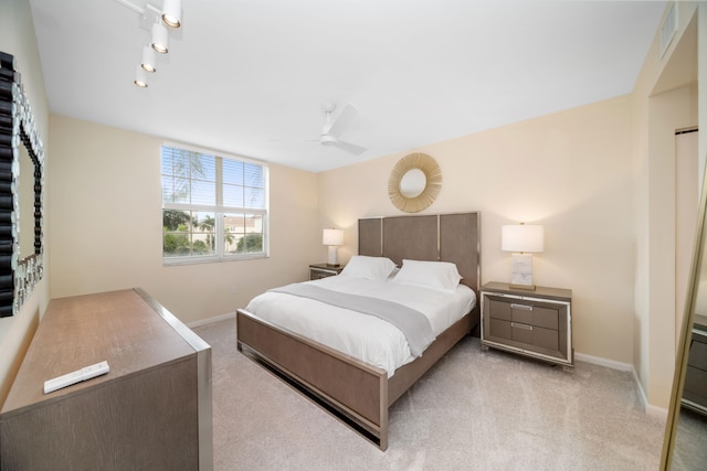 bedroom featuring track lighting, light carpet, and ceiling fan