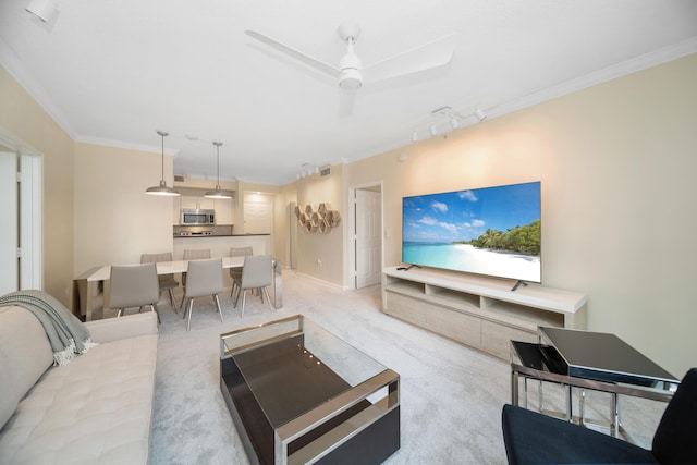 carpeted living room featuring crown molding, ceiling fan, and track lighting