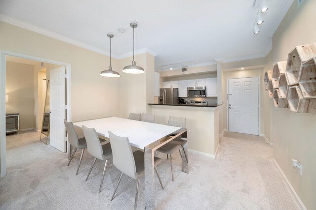 dining room with crown molding, light colored carpet, and track lighting