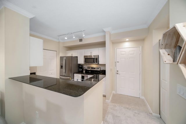 kitchen featuring kitchen peninsula, appliances with stainless steel finishes, dark stone countertops, white cabinets, and rail lighting