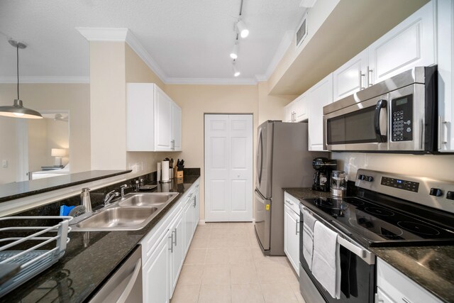 kitchen featuring decorative light fixtures, white cabinetry, appliances with stainless steel finishes, sink, and rail lighting