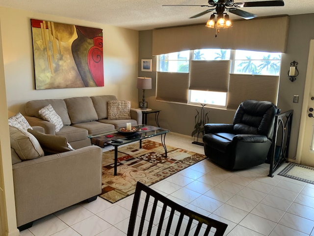 living room with a textured ceiling, ceiling fan, and light tile floors