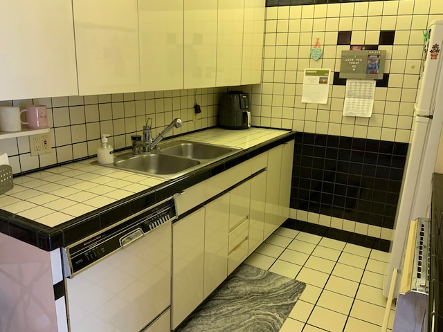 kitchen featuring white dishwasher, light tile flooring, tasteful backsplash, tile countertops, and sink