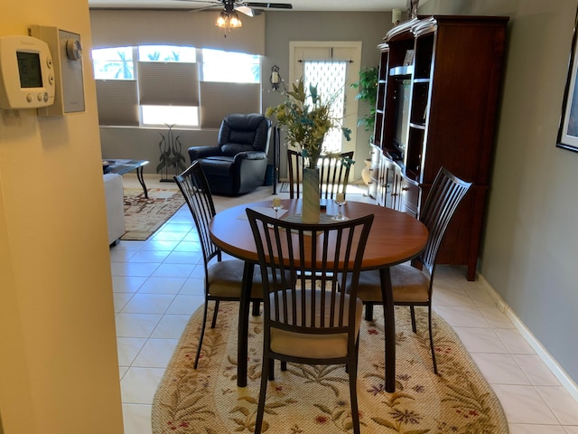 tiled dining space featuring a healthy amount of sunlight and ceiling fan