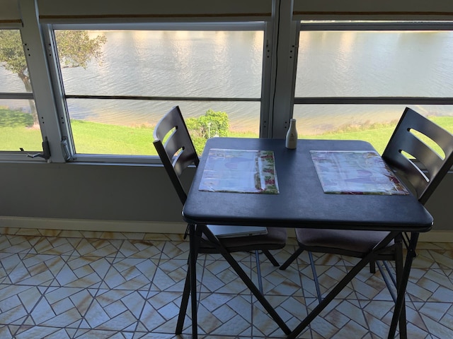 tiled dining area with a water view and a healthy amount of sunlight