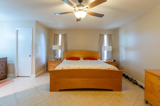 tiled bedroom featuring ceiling fan