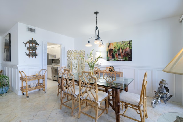 dining room with light tile floors and a chandelier