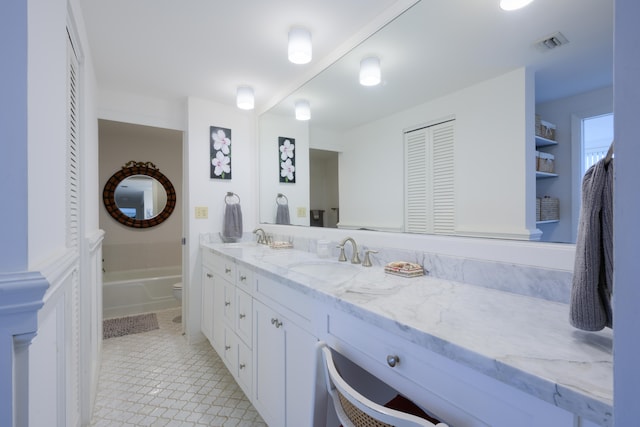 bathroom with toilet, tile floors, and vanity