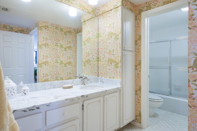 full bathroom with enclosed tub / shower combo, toilet, vanity, and tile flooring