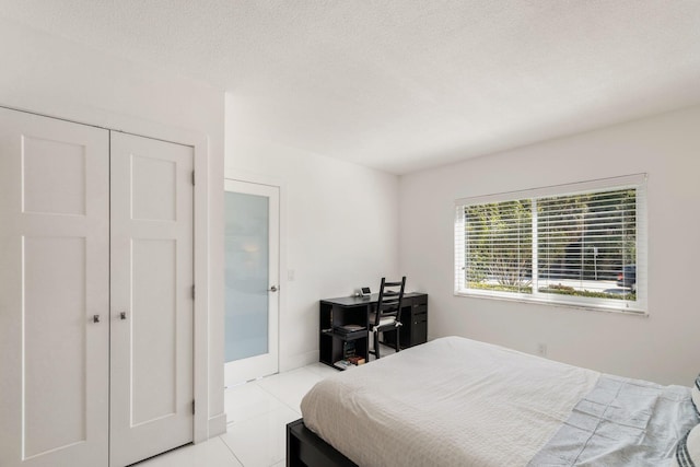 tiled bedroom featuring a closet and a textured ceiling