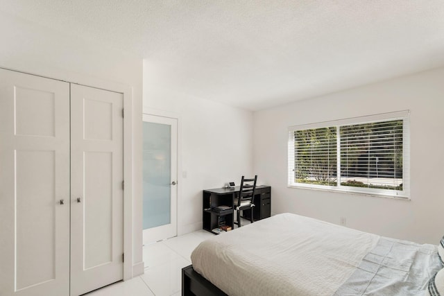 tiled bedroom featuring a textured ceiling and a closet