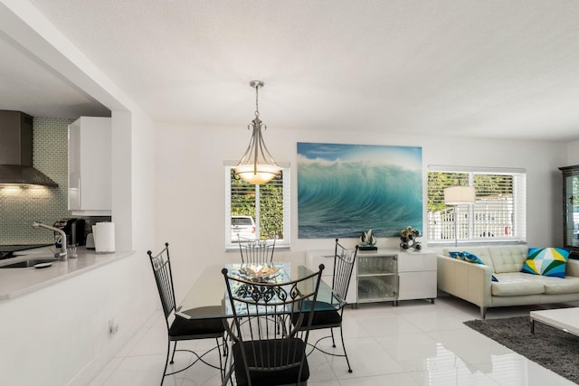 dining space with light tile patterned flooring, sink, and a textured ceiling