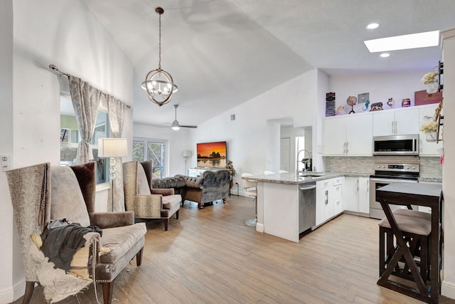 17891 N 86th St N, The Acreage, FL 33470 - kitchen with stainless steel appliances, a peninsula, open floor plan, a sink, and white cabinets