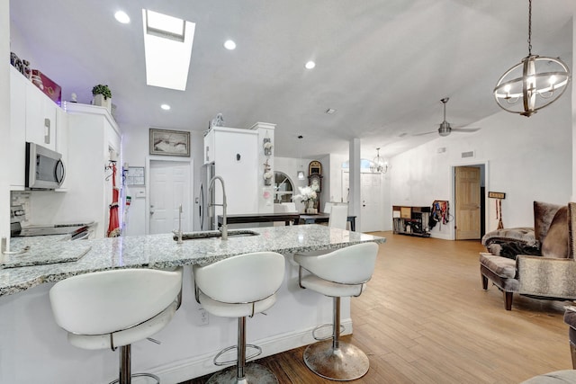 17891 N 86th St N, The Acreage, FL 33470 - kitchen with a chandelier, stainless steel appliances, a peninsula, a sink, and light stone countertops