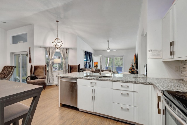 17891 N 86th St N, The Acreage, FL 33470 - kitchen with open floor plan, stainless steel dishwasher, a peninsula, vaulted ceiling, and white cabinetry