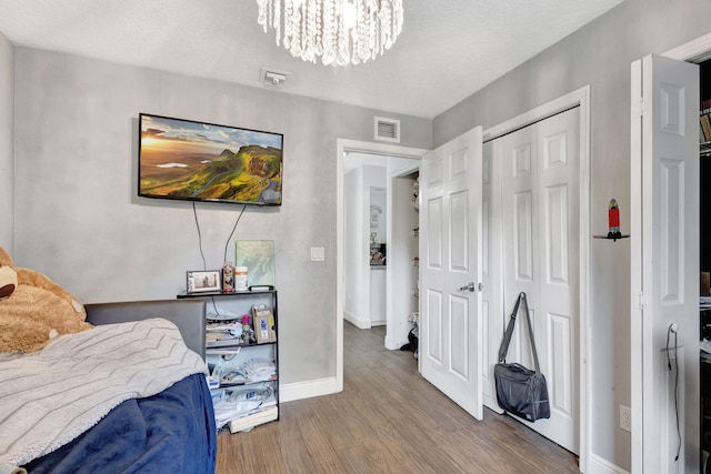 17891 N 86th St N, The Acreage, FL 33470 - bedroom with wood finished floors, a chandelier, baseboards, a textured ceiling, and a closet
