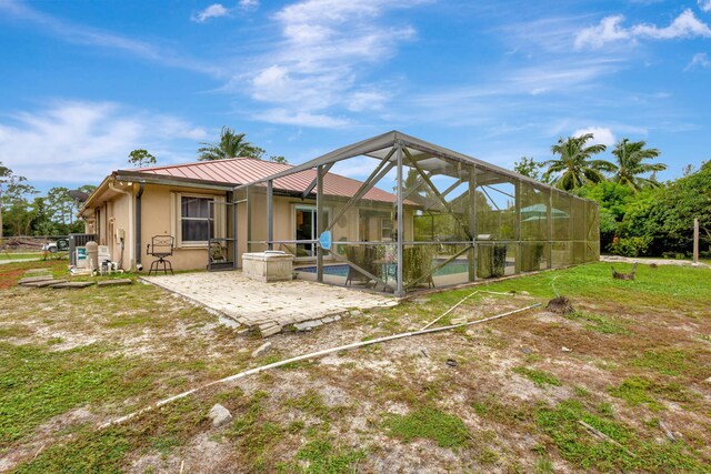 17891 N 86th St N, The Acreage, FL 33470 - back of property with a patio area, an outdoor pool, stucco siding, metal roof, and a standing seam roof