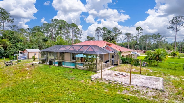 17891 N 86th St N, The Acreage, FL 33470 - rear view of property featuring a patio area, glass enclosure, metal roof, view of scattered trees, and an outbuilding